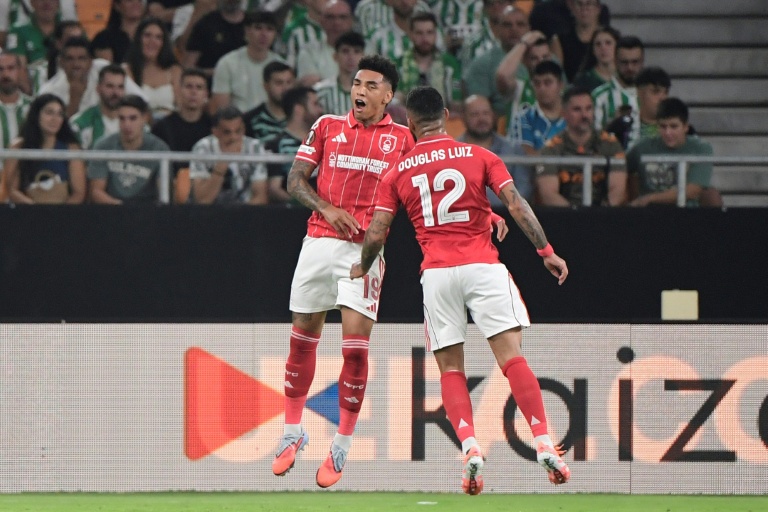 المهاجم البرازيلي لنوتنغهام فوريست الإنكليزي إيغور جيسوس (#19) يحتفل مع مواطنه دوغلاس لويز (#12) بعد تسجيل الهدف الأول لفريقه في مرمى ريال بيتيس الإسباني ضمن منافسات الجولة الأولى من دور المجموعة الموحدة لمسابقة الدوري الأوروبي في كرة القدم. إشبيلية، في 24 أيلول/سبتمبر 2025.