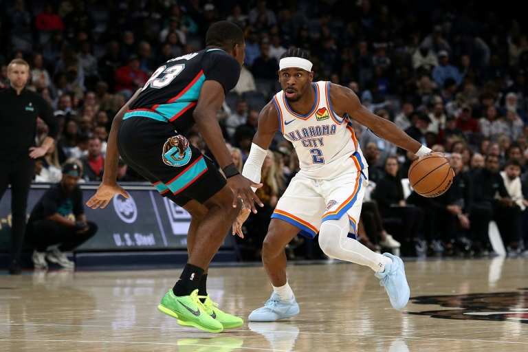 الكندي شاي غلجيوس-ألكسندر لاعب اوكلاهوما سيتي ثاندر يحاول الاختراق وسط مضايقة دفاعية من سيدريك كاورد لاعب ممفيس غريزليز خلال لقاء الفريقين ضمن دوري كرة السلة الأميركي الأحد في 9 تشرين الثاني/نوفمبر 2025