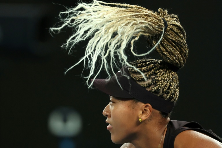 اليابانية ناومي أوساكا أثناء إرسال الكرة في مباراتها الفردية ضد الفرنسية كارولين غارسيا في اليوم الثاني من بطولة أستراليا المفتوحة لكرة المضرب في ملبورن، في 13 كانون الثاني/يناير 2025.