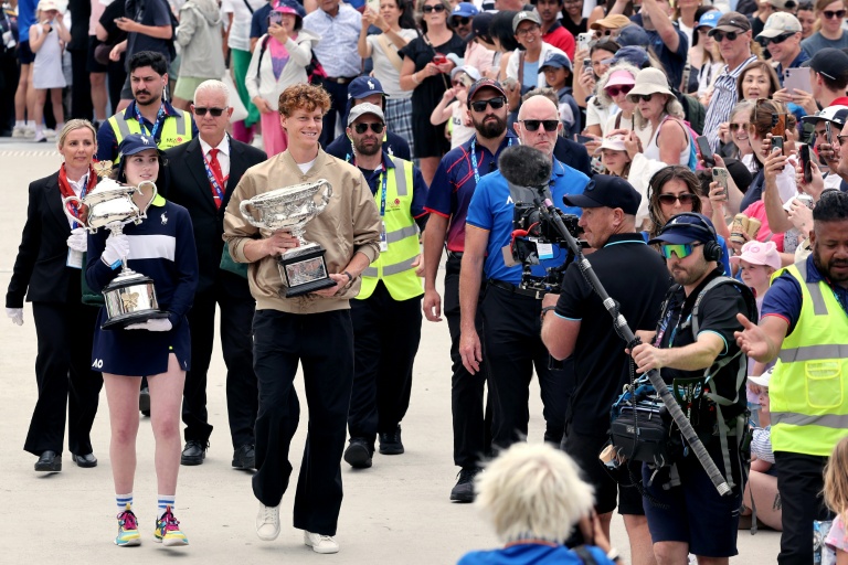 الايطالي يانيك سينر (وسط) يحمل كأس بطولة أستراليا المفتوحة لكرة المضرب خلال مراسم سحب القرعة. ملبورن في 15 كانون الثاني/يناير 2026