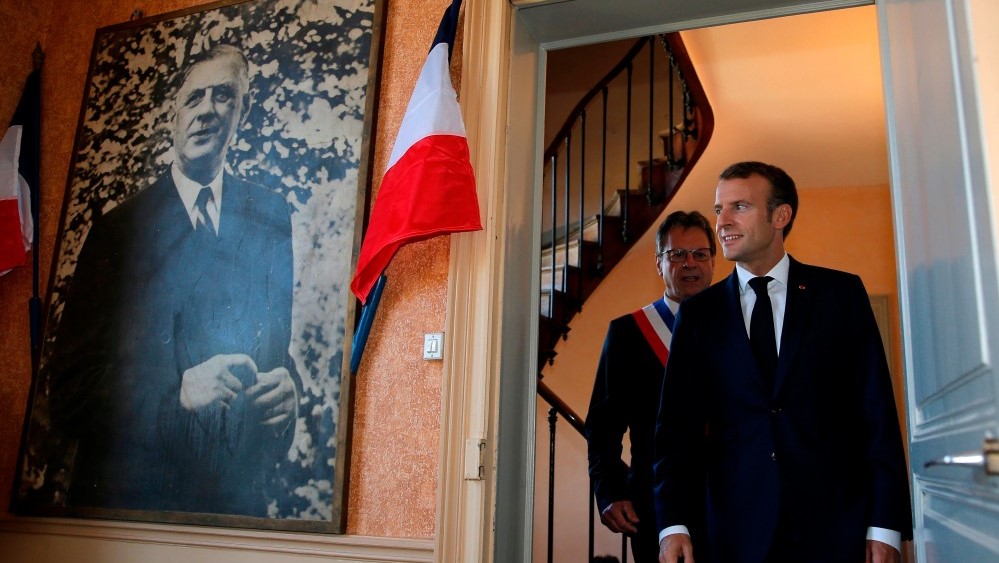 الرئيس الفرنسي إيمانويل ماكرون وإلى يمينه صورة الرئيس الفرنسي الأسبق شارل ديغول