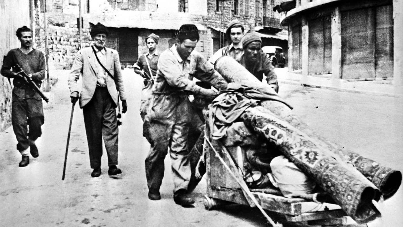 أعضاء من منظمة الهاغاناه شبه العسكرية يرافقون فلسطينيين مطرودين من حيفا بعد سيطرة القوات اليهودية عليها في أبريل 1948