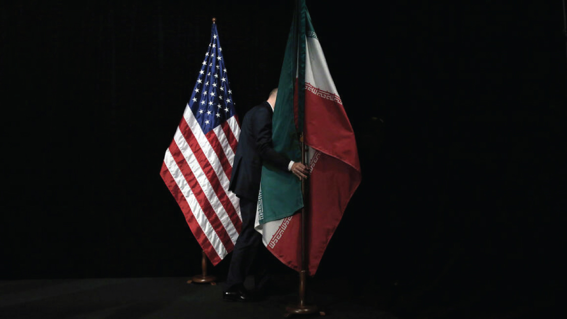 موظف يرفع العلم الإيراني من على المسرح بعد صورة جماعية لوزراء خارجية وممثلي الولايات المتحدة وإيران والصين وروسيا وبريطانيا وألمانيا وفرنسا والاتحاد الأوروبي خلال المحادثات النووية الإيرانية في مركز النمسا الدولي في فيينا، النمسا، في 14 يوليو 2015