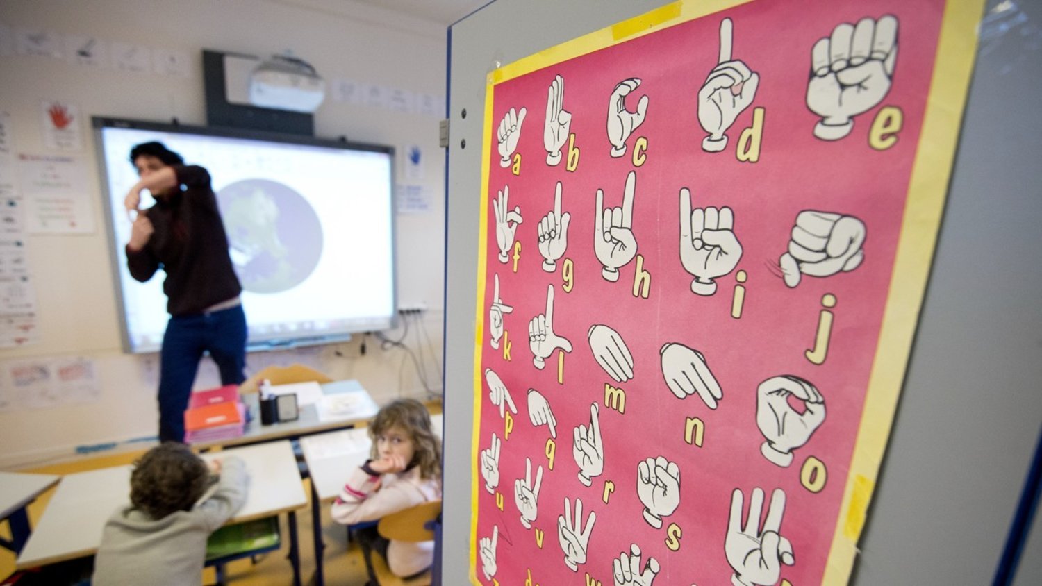 مدرس يستخدم لغة الإشارة للتواصل مع التلاميذ ضعاف السمع في إحدى المدارس في فرنسا