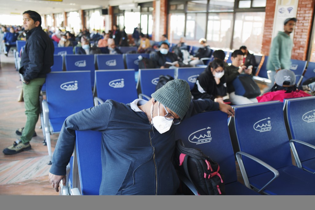 مسافرون في مطار كاتمندو ينتظرون رحلتهم فيما يرتدي غالبيتهم الاقنعة الطبية