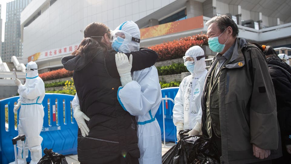 عاملون في مجال الصحة يتبادلون التهاني في يووهان بعد أن أعلنت الصين احتواء كورونا في أول بؤرة ظهر فيها