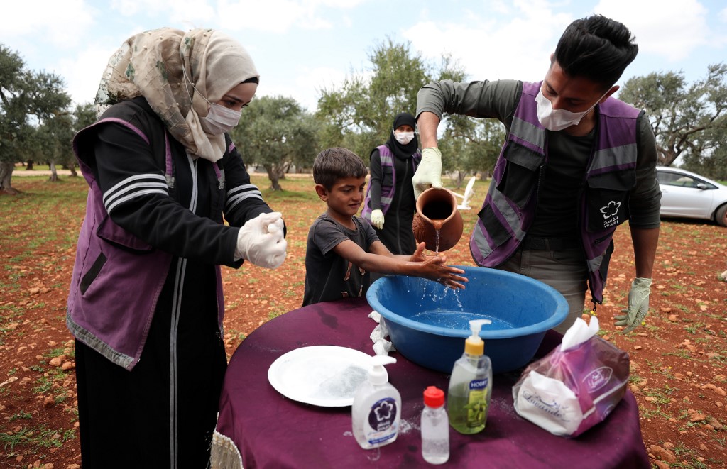 متطوع في إدلب السورية يعلّم نازحين الطريقة المثلى لغسل اليدين توقيا من فيروس كورونا