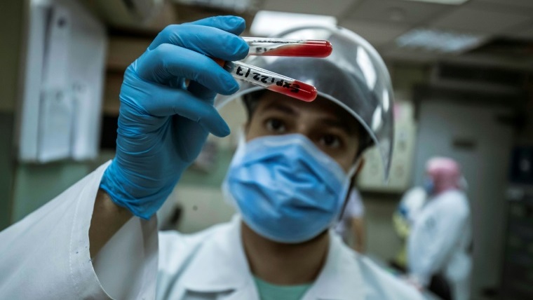 عامل في القطاع الصحي المصري يختبر عينة دم من متبرع