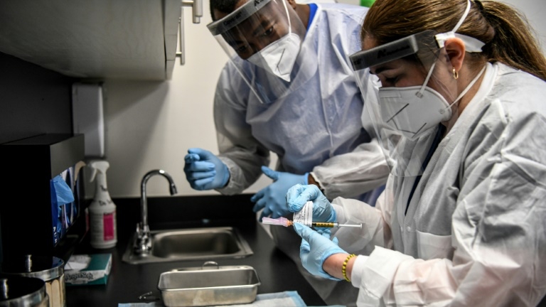 عاملان في المجال الطبي يحضران لقاح مضاد لكوفيد-19 للاستخدام مراكز البحوث الأمريكية في هوليوود في ولاية فلوريدا في 13 أغسطس 2020