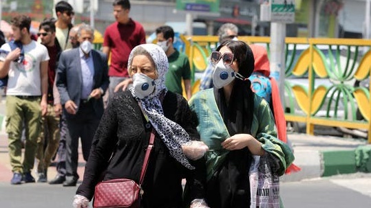 سيدتان إيرانيتان تضعان الكمامة في الطريق العام