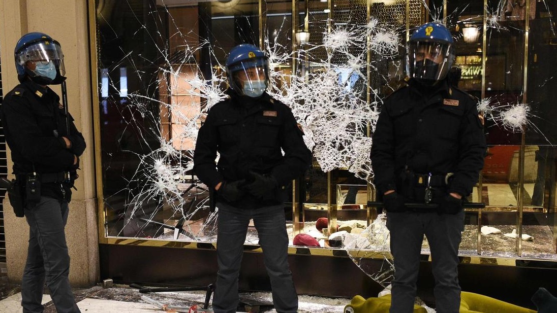 الشرطة الايطالية أمام واجهة محل تعرضت للتكسير من قبل االمحتجين