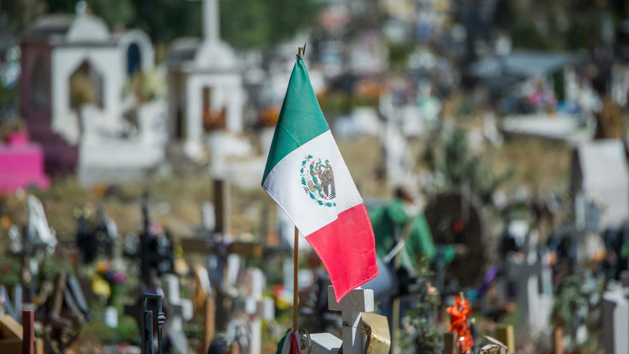 العلم المكسيكي مرفوعاً أمام مقبرة في فالي دي شالكو بولاية مكسيكو في المكسيك في 19 ت2/نوفمبر 2020