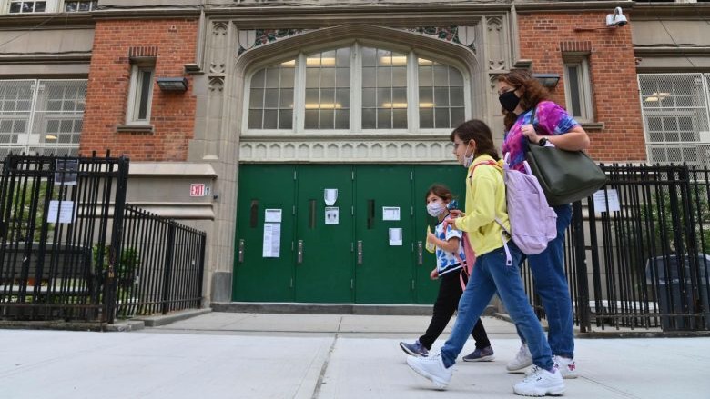 طلاب يمشون أمام مدرسة رسمية في مدينة نيويورك