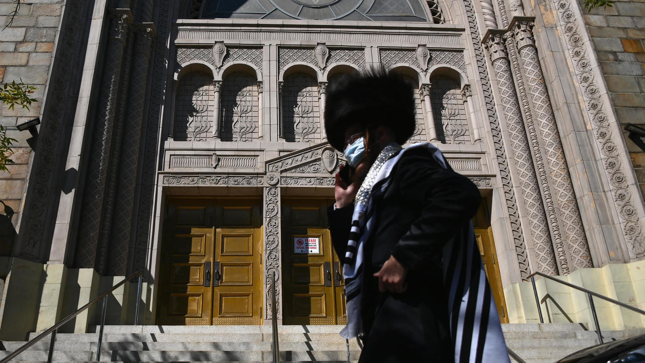 رجل يهودي من الحسيديم يمر أمام كنيس مغلق في حي بروكلين النيويوركي في 9 ت1/أكتوبر 2020