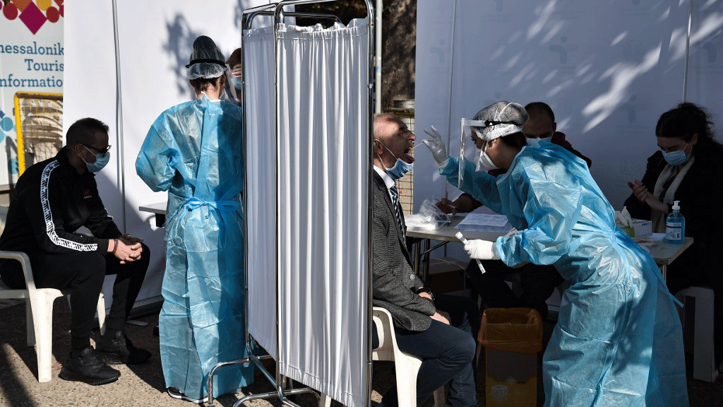 فريق صحي يشرف على فحص مصابين محتملين بالفيروس في أحد شوارع تسالونيكي