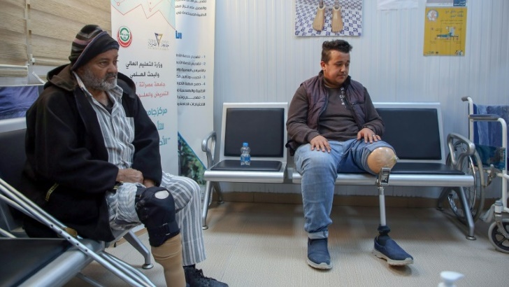 مصابان مبتورا الأطراف ينتظرون دورهم للمعاينة في المركز الوطني للأطراف الصناعية في مصراتة