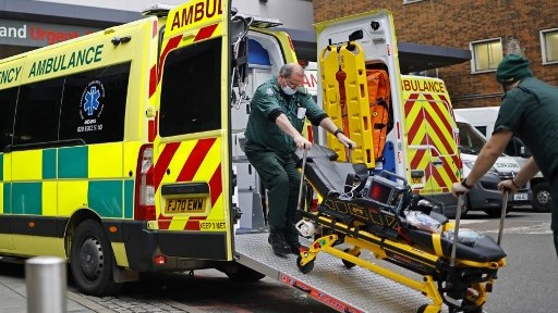 عاملان صحيان بريطانيان يستعدان لنقل أحد المصابين بسلالة كورونا المتحورة في 27 ديسمبر الجاري