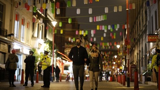 بريطانيان وسط لندن في 31 ديسمبر الماضي يرتديان الكمامة فيما الحركة خفيفة بسبب الإجراءات الصحية الصارمة