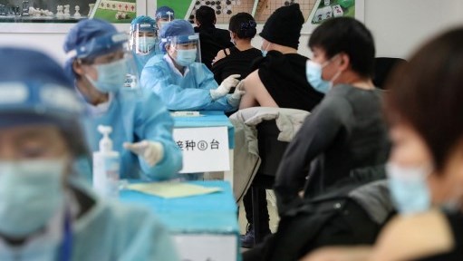 صينيون يتلقون اللقاح ضد كورونا الجمعة في أحد مراكز التلقيح في بكين