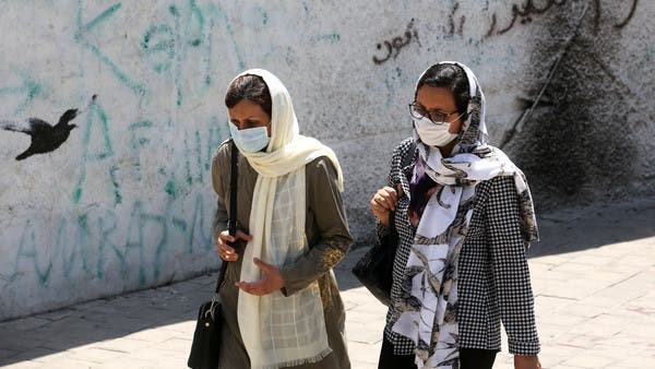 إيرانيتان ترتديان الكمامة تمران في أحد شوارع طهران