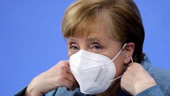 المستشارة الألمانية أنجيلا ميركل تزيل قناع وجهها قبل مؤتمر صحفي في برلين الإثنين