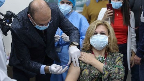 وزير الصحة اللبناني حمد حسن يعطي جرعة من لقاح فايزر لعضو في الطاقم الطبي في مستشفى رفيق الحريري الحكومي في بيروت الأحد