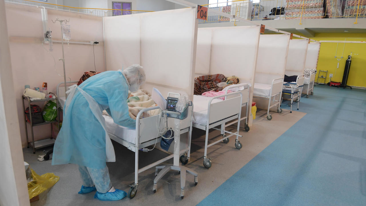 طبيب يهتم بمرض بكوفيد-19 في مستشفى ميداني في قاعة رياضية في تونس في الثاني من شباط/فبراير 2021