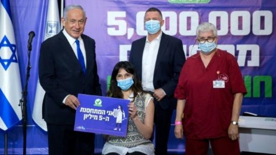  رئيس وزراء إسرائيل بنيامين نتانياهو في صورة مع إسرائيلي صار معه عدد من تلقوا لقاحًا ضد كورونا خمسة ملايين في آذار/مارس 2021 