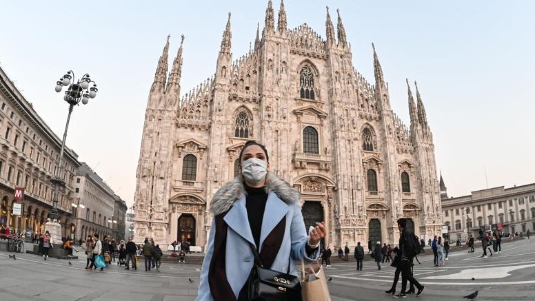 امرأة ترتدي قناعًا طبيًا في ساحة ديومو في ميلانو الإيطالية