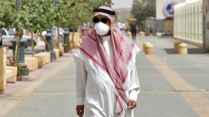 سعودي يرتدي القناع الطبي في أحد شوارع الرياض