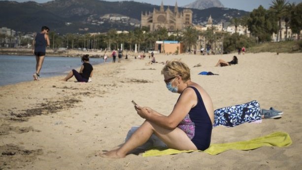 إسبانية بالكمامة ترتاد شاطئًا في منطقة مايوركا