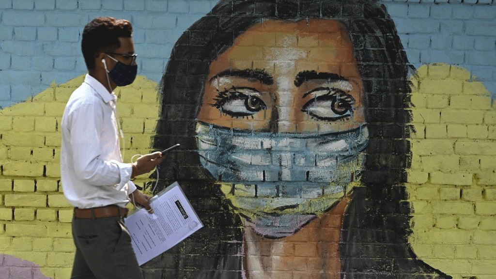 رجل يمر أمام جدارية تعبيرية في نيودلهي