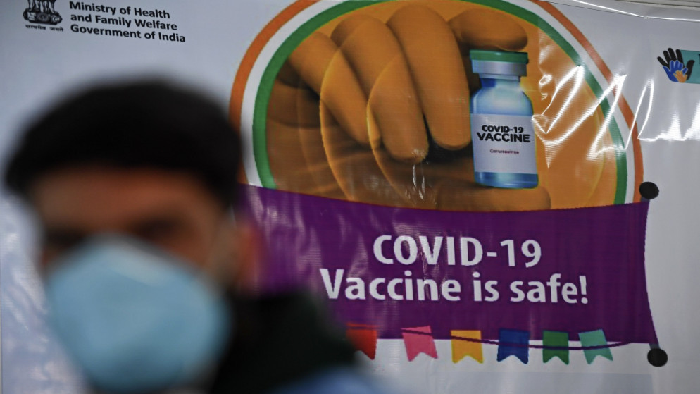 عامل طبي يمر بجانب لافتة أثناء التطعيم المستمر ضد فيروس كورونا. 22 يناير 2021