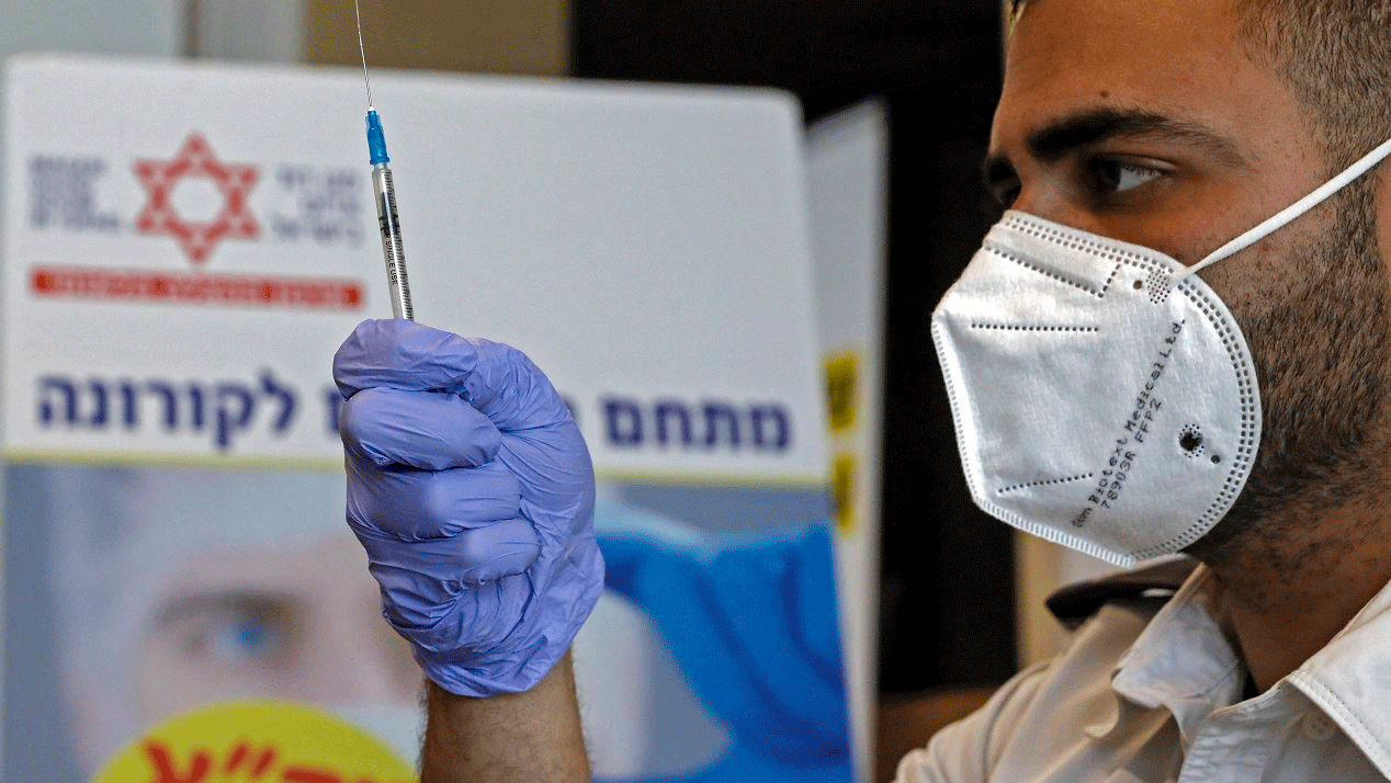 عامل صحّي إسرائيلي يحضّر جرعة من لقاح 