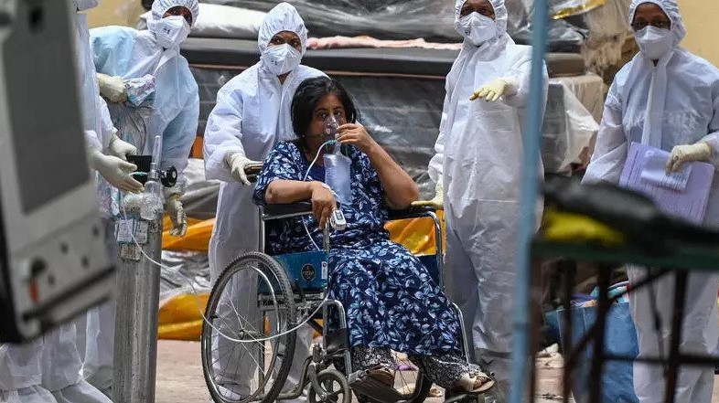 مسعفون ينقلون امرأة إلى وحدة العناية الفائقة المخصصة لمرضى كوفيد في بومباي في 22 نيسان/ابريل 2021