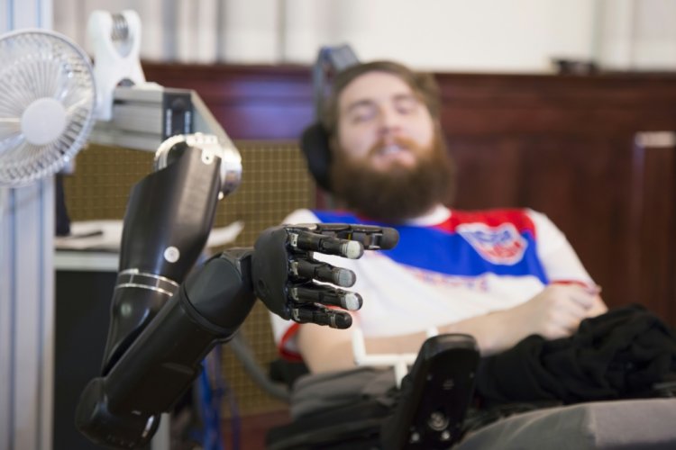ناثان كوبلاند يحرك ذراعا آلية باستخدام أقطاب كهربائية مزروعة في دماغه، في صورة غير مؤرخة نشرتها جامعة بيتسبرغ