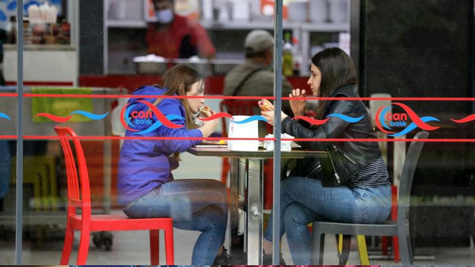 فتاتان تتناولان الطعام في مقهى أعيد افتتاحه في أنقرة، تركيا، 2 حزيران/ يونيو 2021