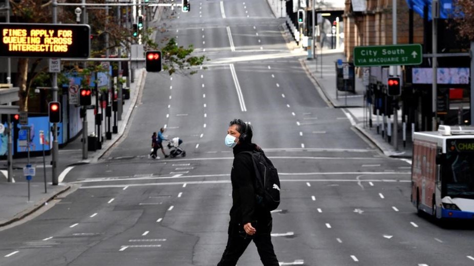  رجل يسير على طول الطريق الرئيسي في الحي التجاري المركزي في سيدني ، 26 يونيو 2021 ، حيث دخلت أكبر مدينة في أستراليا في إغلاق لمدة أسبوعين لاحتواء تفشي متحور دلتا