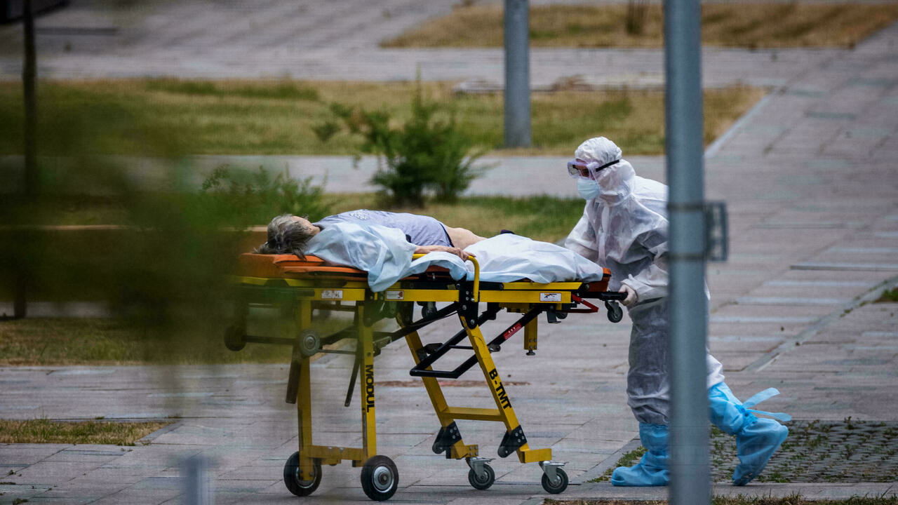 عامل طبي ينقل امرأة الى المستشفى حيث يعالج المصابون بكورونا في كوموناركا قرب موسكو في 30 حزيران/يونيو 2021