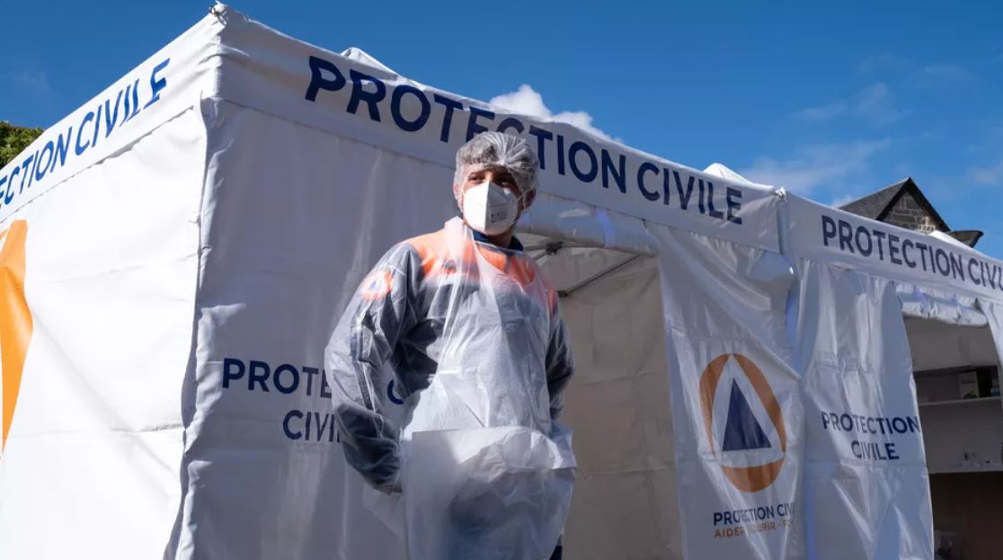 عضو في الحماية المدنية ينتظر أمام منصة عرض كوفيد-19 في 5 مايو 2021 ، في برونز في كوت دي أرمور