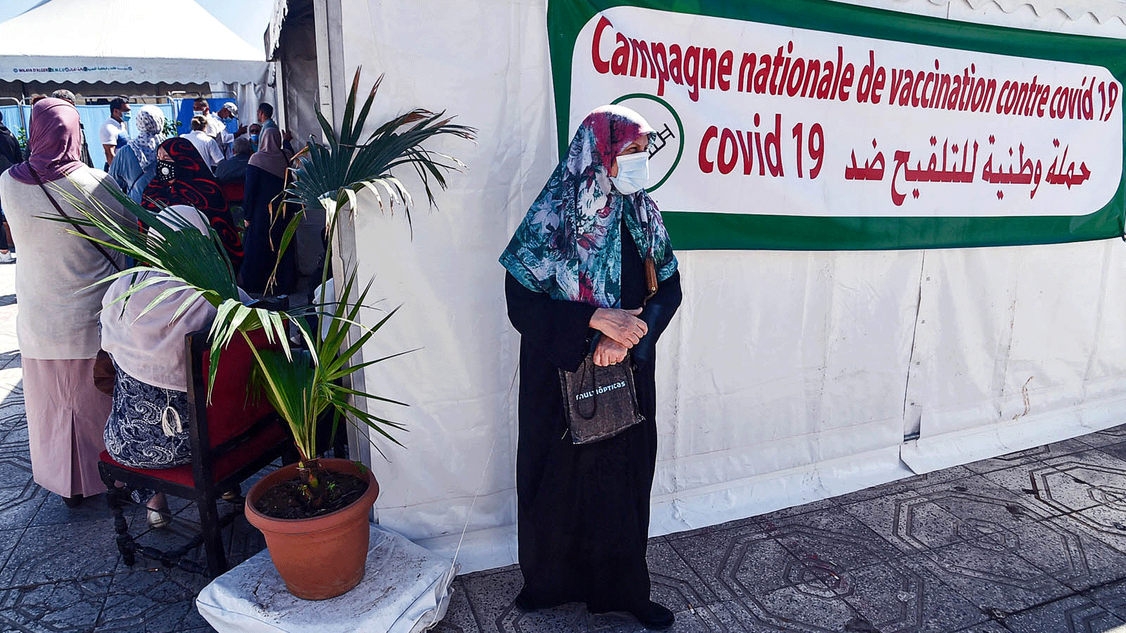 امرأة تنتظر خارج أحد مراكز التلقيح في الجزاذر في 7 حزيران/يونيو 2021
