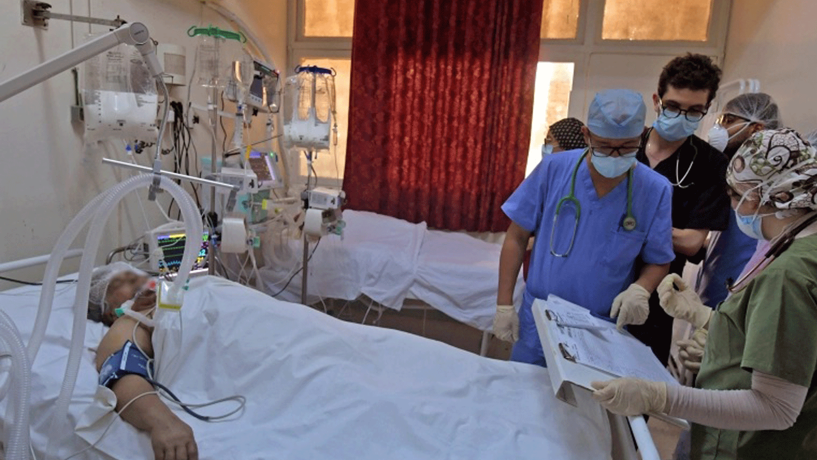 مسعفون تونسيون يعتنون بمرضى في صالة رياضية تم تحويلها إلى منشأة طبية للتعامل مع زيادة حالات الإصابة بفيروس كورونا في مدينة القيروان