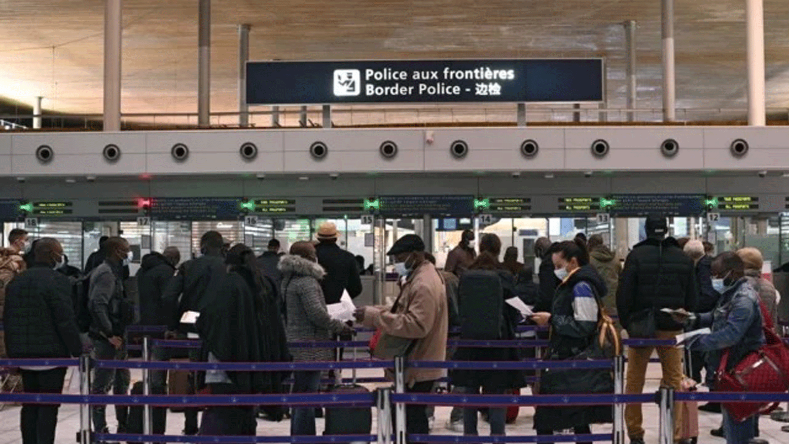مسافرون يعدون وثائقهم أثناء وقوفهم بطابور في مكتب الهجرة بمطار رواسي شارل ديغول الدولي، مع دخول القيود الجديدة بمواجهة COVID-19 حيّز التنفيذ. 1 شباط/فبراير 2021.