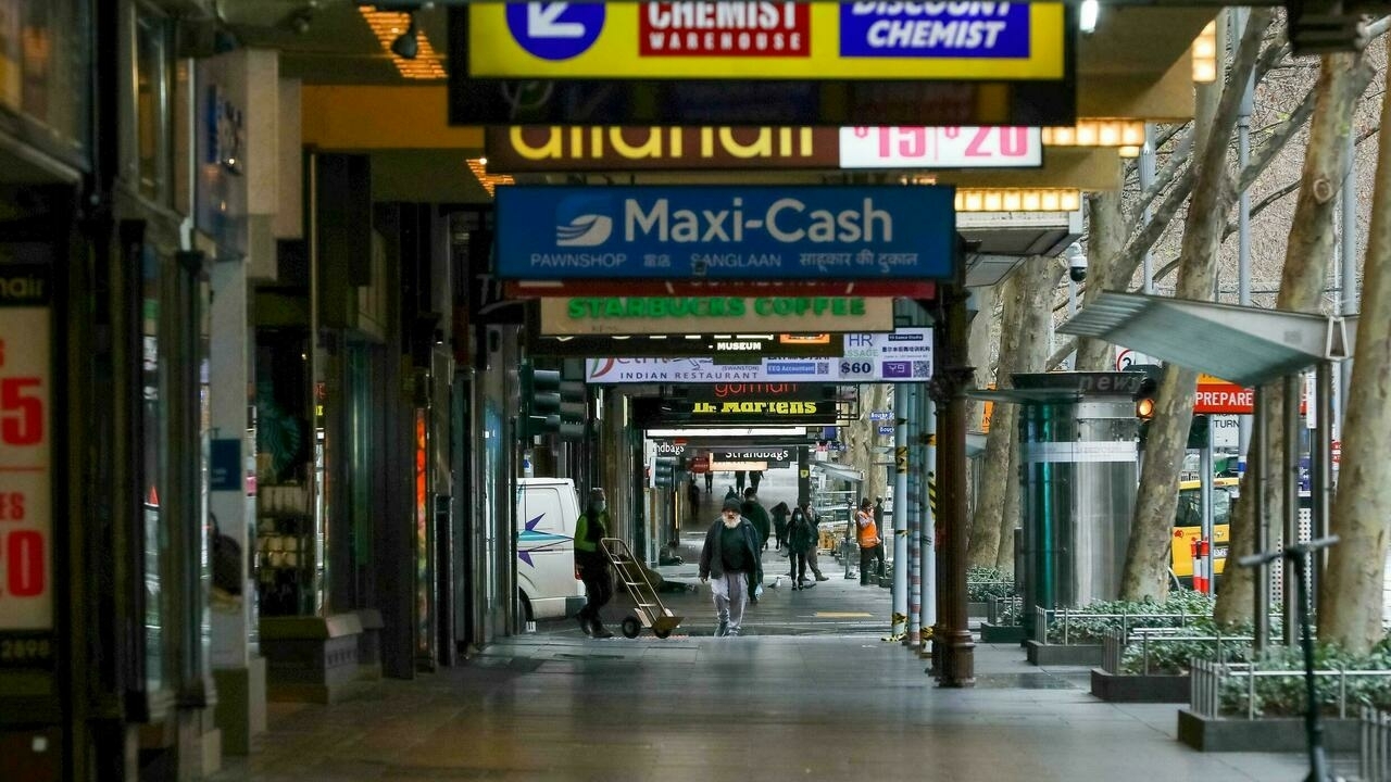 عدد قليل من الناس يسيرون في شارع سوانستون الهادئ في مبلورن وسط تدابير إغلاق، في 16 تموز/يوليو 2021