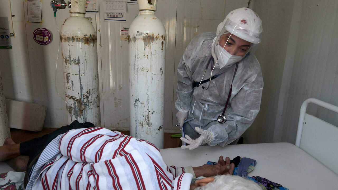 ممرضة تونسية تضع بدلة واقية ترعى مصابا بفيروس كورونا في وحدة رعاية مركزة بمستشفي في ولاية باجة شمال غرب البلاد بتاريخ 22 حزيران/يونيو 2021