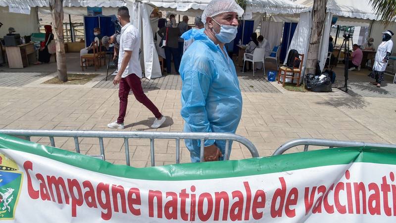 ممرض يقف أمام مركز للتطعيم ضد كوفيد أمام المسجد الكبير في العاصمة الجزائرية