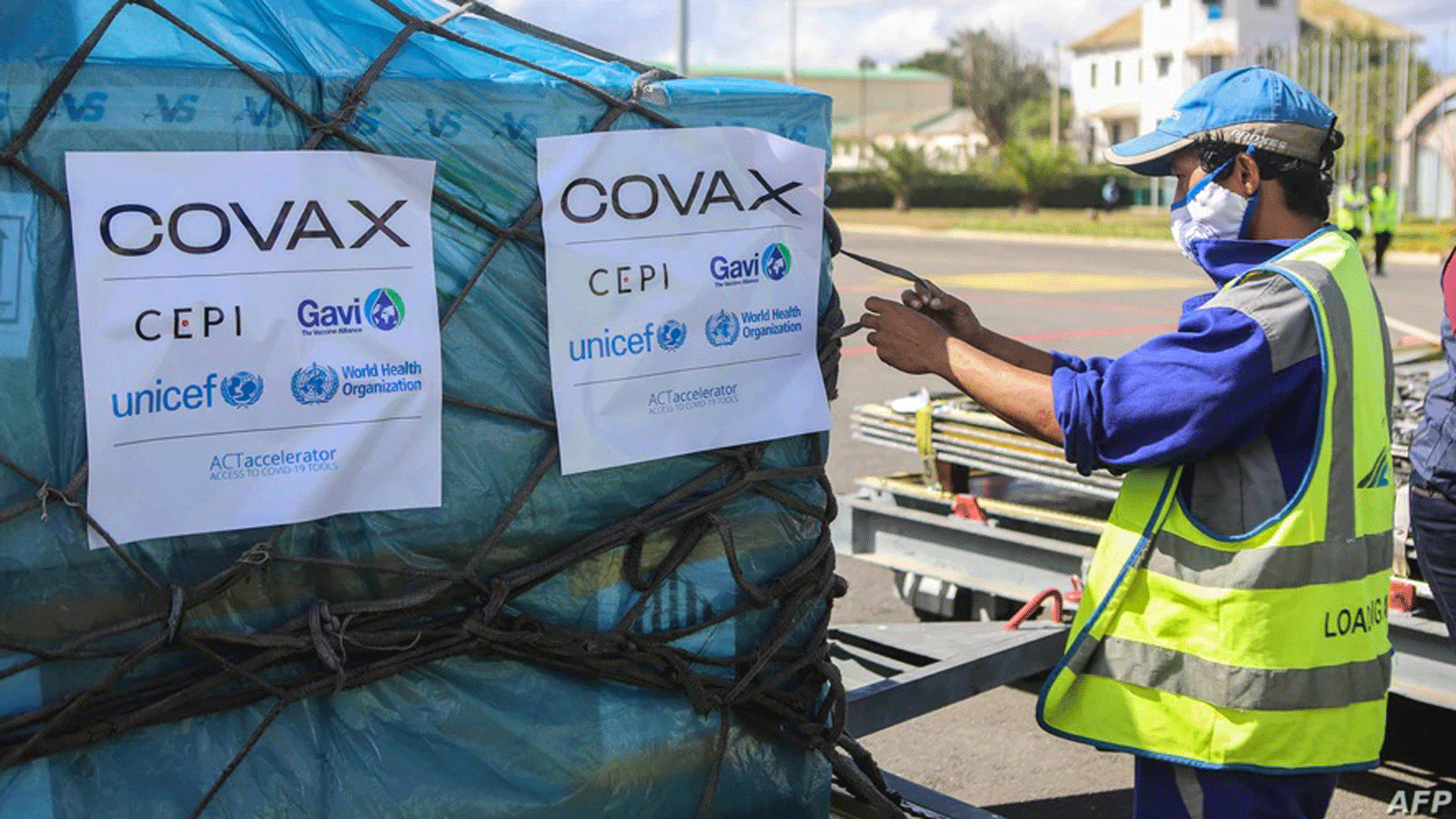 عامل يتعامل مع صناديق لقاحات COVID-19، تم تسليمها كجزء من برنامج توزيع لقاحات COVAX العادل، في مطار إيفاتو الدولي، في أنتاناناريفو، مدغشقر، 8 أيار/مايو 2021.