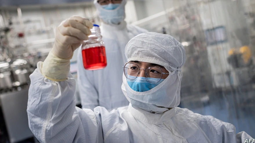 عالم ينظر إلى خلايا لكلى القرد أثناء اختباره لقاحًا تجريبيًا لفيروس كورونا كوفيد-19 داخل مختبر غرفة ثقافة الخلايا في منشآت سينوفاك بيوتك في بكين. بتاريخ 29 نيسان/ أبريل 2020.