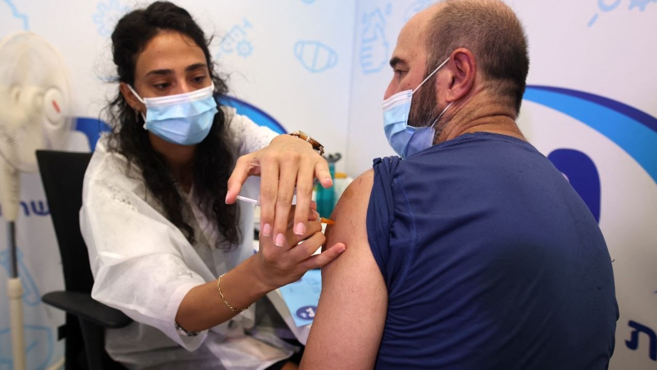 رجل يتلقى جرعة ثالثة من لقاح فايزر- بايونتيك في مركز مكابي الصحي في بلدة ريشون لتسيون الإسرائيلية في 13 اغسطس 2021