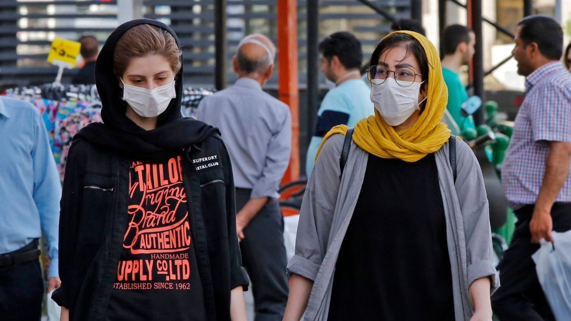 إيرانيتان بالقناع الطبي تسيران في أحد شوارع طهران في فبراير 2020